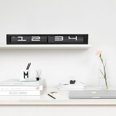 Digitaluhr schwarz auf Regal über Schreibtisch