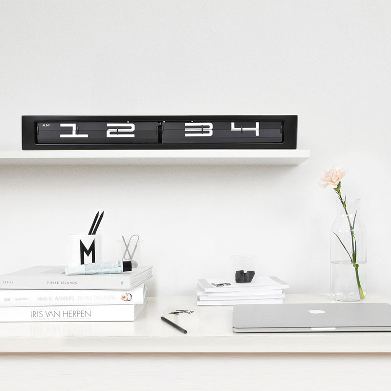 Digitaluhr schwarz auf Regal über Schreibtisch
