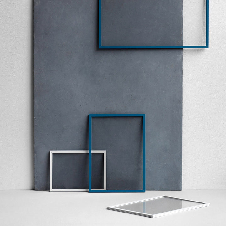 blaue und weiße Rahmen vor grauer Wand